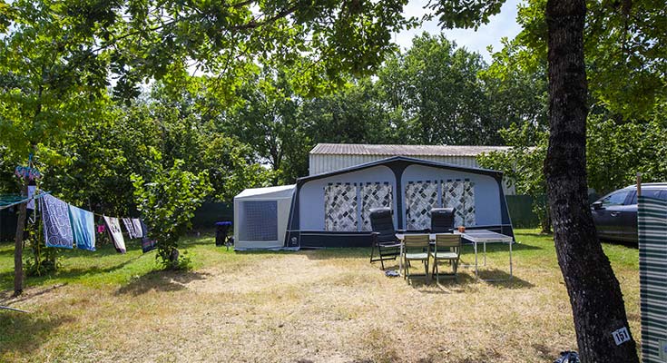 emplacement ombragé avec caravane et auvent