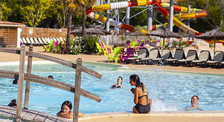 vacanciers s'amusant dans le bassin extérieur du parc aquatique